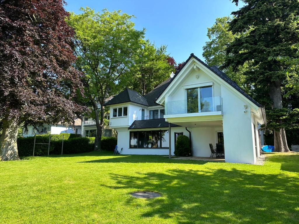 uma casa branca com um quintal com relva verde em Villa Noho em Nonnenhorn