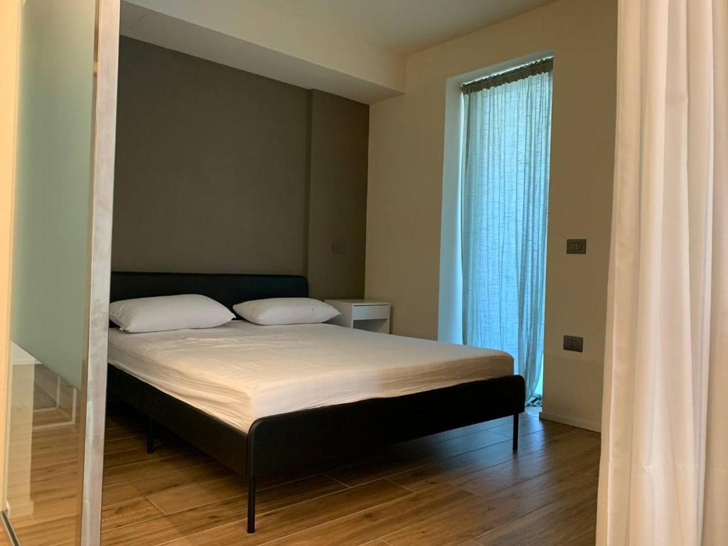 ein Schlafzimmer mit einem Bett und einem großen Fenster in der Unterkunft [Riviera Apartments] Near the beach + Parking in Rosolina Mare