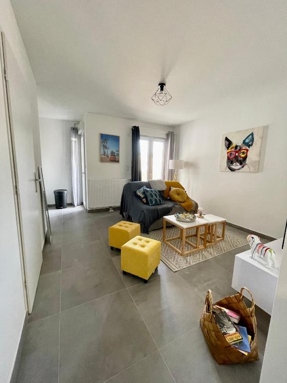 un salon avec un canapé et une table dans l'établissement Studio Neuf à 10min Plage & Centre-Ville + Garage, à Ajaccio