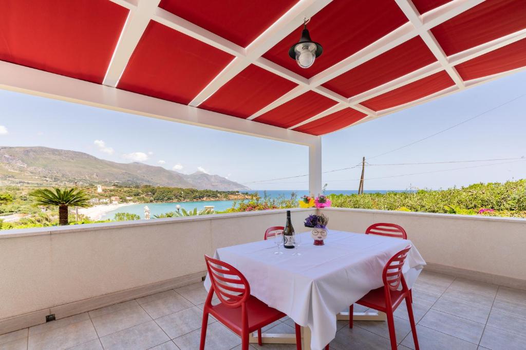 una mesa y sillas en un balcón con vistas al océano en Casa Verde, en Castellammare del Golfo