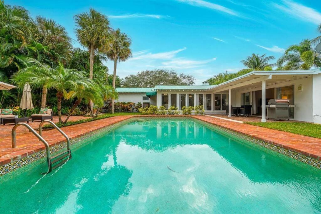 a swimming pool in front of a house at Intracoastal Paradise Walking Distance to Beach! in West Palm Beach