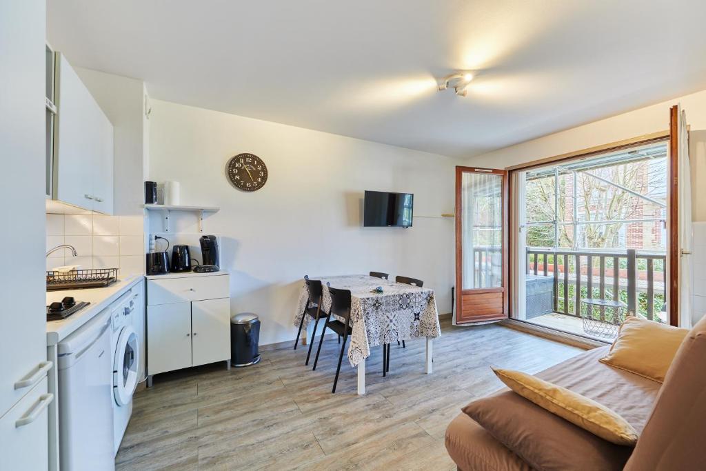 une cuisine et une salle à manger avec une table et une cuisine ainsi qu'une chambre dans l'établissement Sea Blue - Appt à 1km de la plage, à Villers-sur-Mer