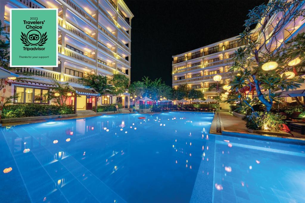 a swimming pool in front of a hotel at night at Hoi An Central Boutique Hotel & Spa (Little Hoi An Central Boutique Hotel & Spa) in Hoi An