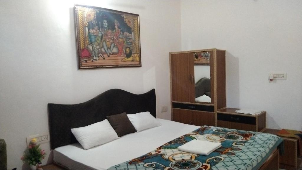 um quarto com uma cama e um espelho em Peaceful Home Stay em Khajurāho
