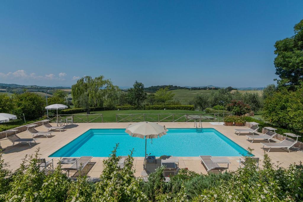 una piscina con sillas y sombrilla en Villa Il Fiore e la Farfalla 14 en Pesaro