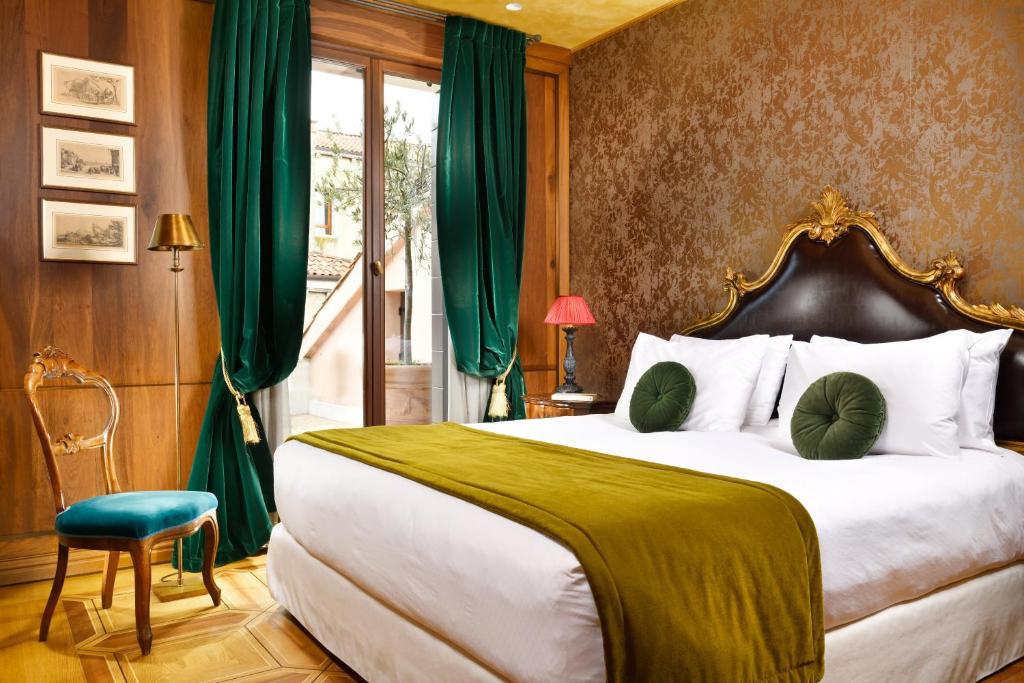 a bedroom with a large bed with green curtains at Palazzo Venart Luxury Hotel in Venice