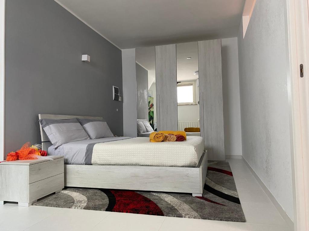 een slaapkamer met een groot bed en een spiegel bij Ginevra Petite Maison in Termoli