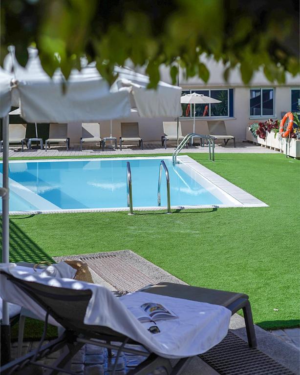 - une piscine avec une chaise en face dans l'établissement Cornisa Apartments, à Patalavaca
