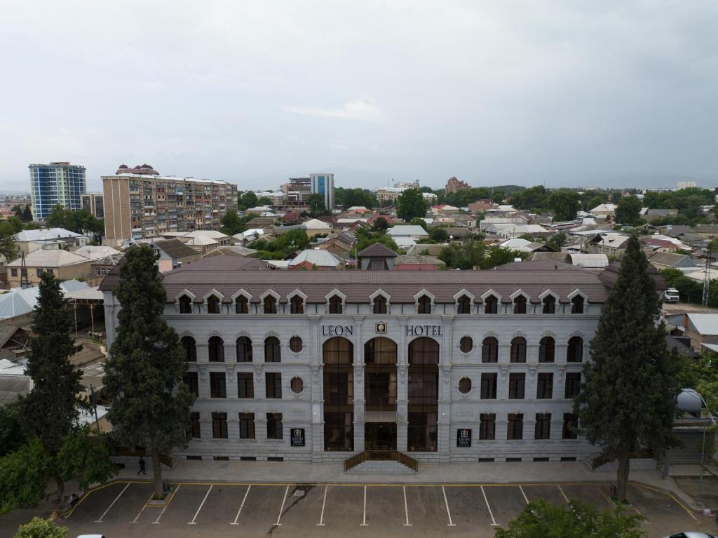 a large white building with a city in the background at Leon Hotel Spa Ganja in Ganja