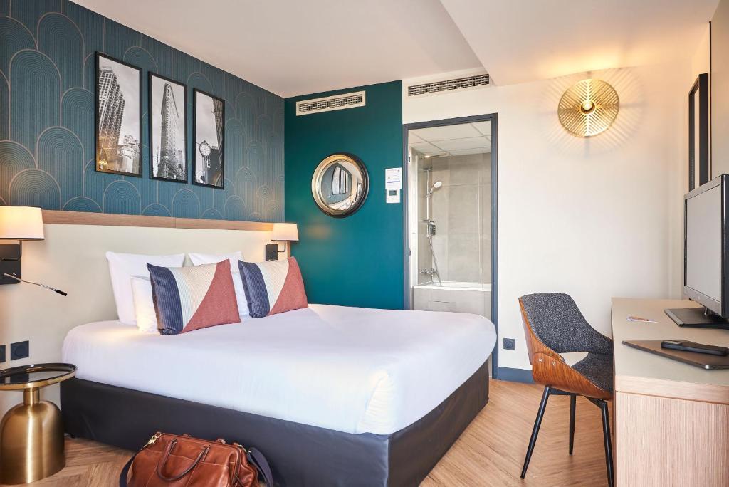 Cette chambre comprend un grand lit et un bureau. dans l'établissement Hotel Gatsby by HappyCulture, à Chassieu