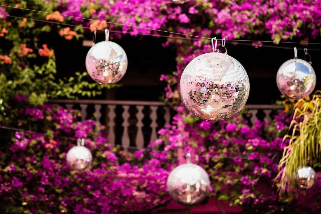 a group of balls hanging from a string with purple flowers at Pikes Ibiza in San Antonio