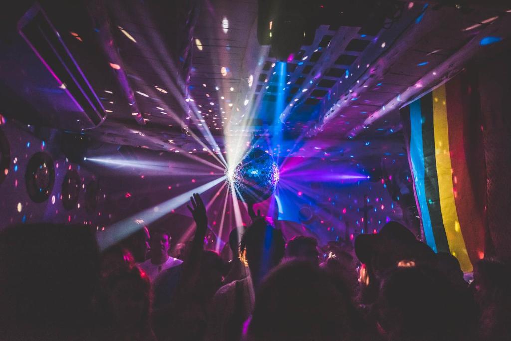 a group of people dancing in a nightclub with lights at Pikes Ibiza in San Antonio