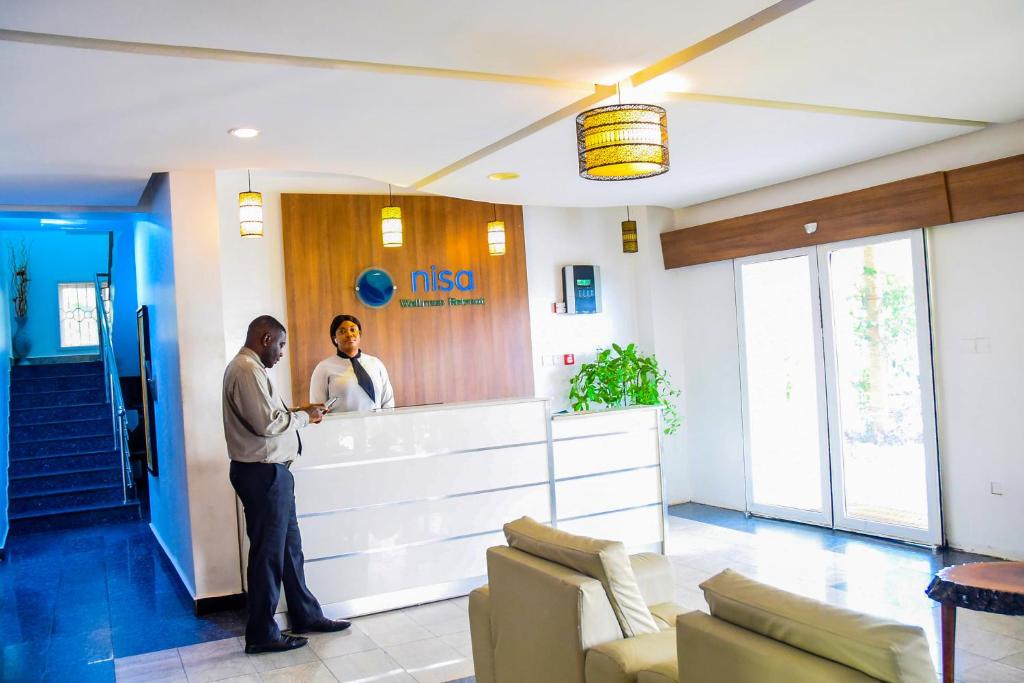 two men standing at a reception counter in a hospital at Nisa Wellness Retreat in Abuja