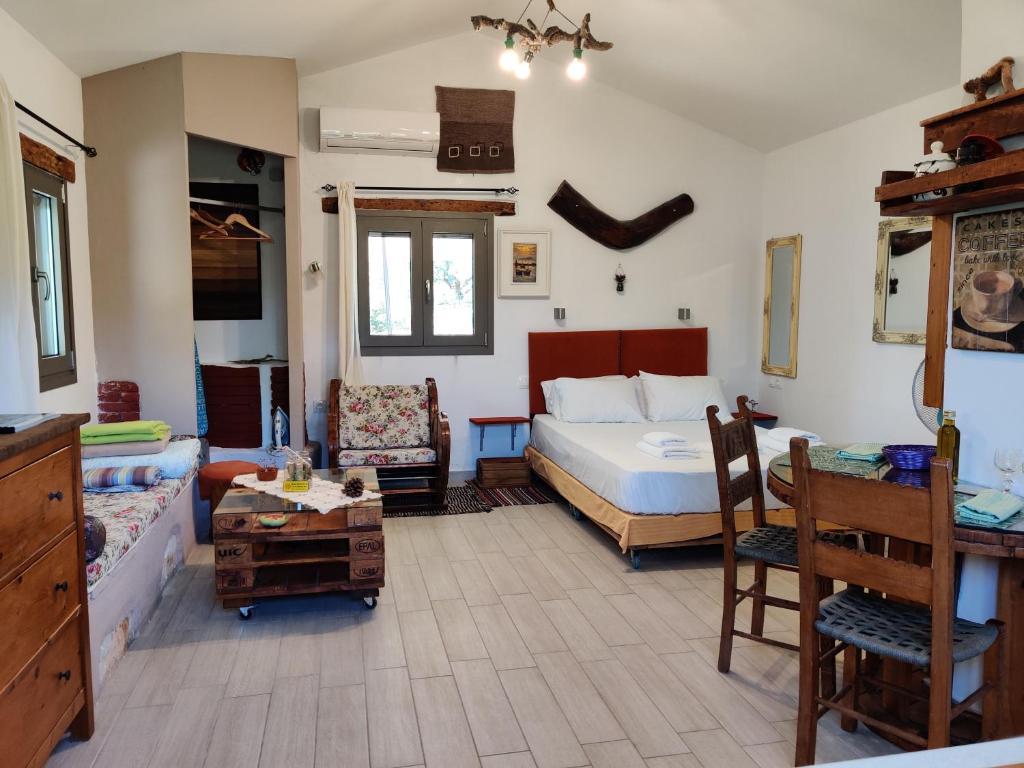 GalatásにあるOlea Cottageのベッドルーム1室(ベッド1台、テーブル、椅子付)