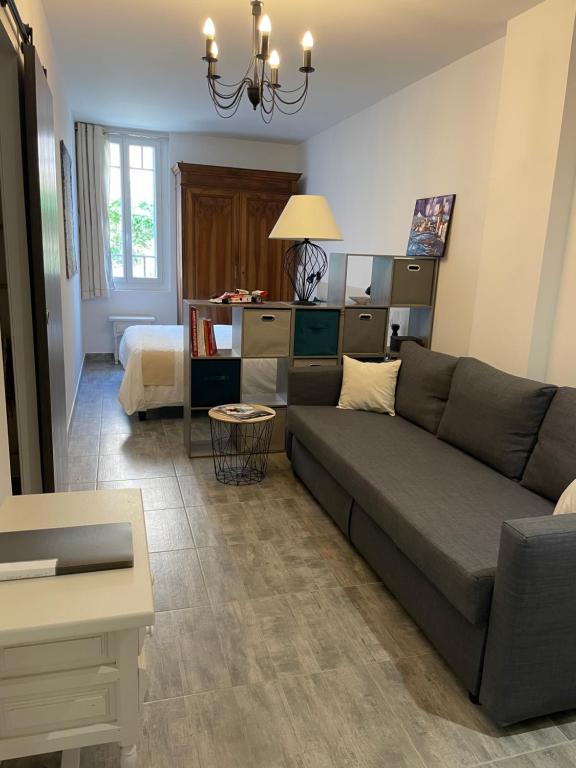 uma sala de estar com um sofá e um quarto em L'Olivier em Cabestany
