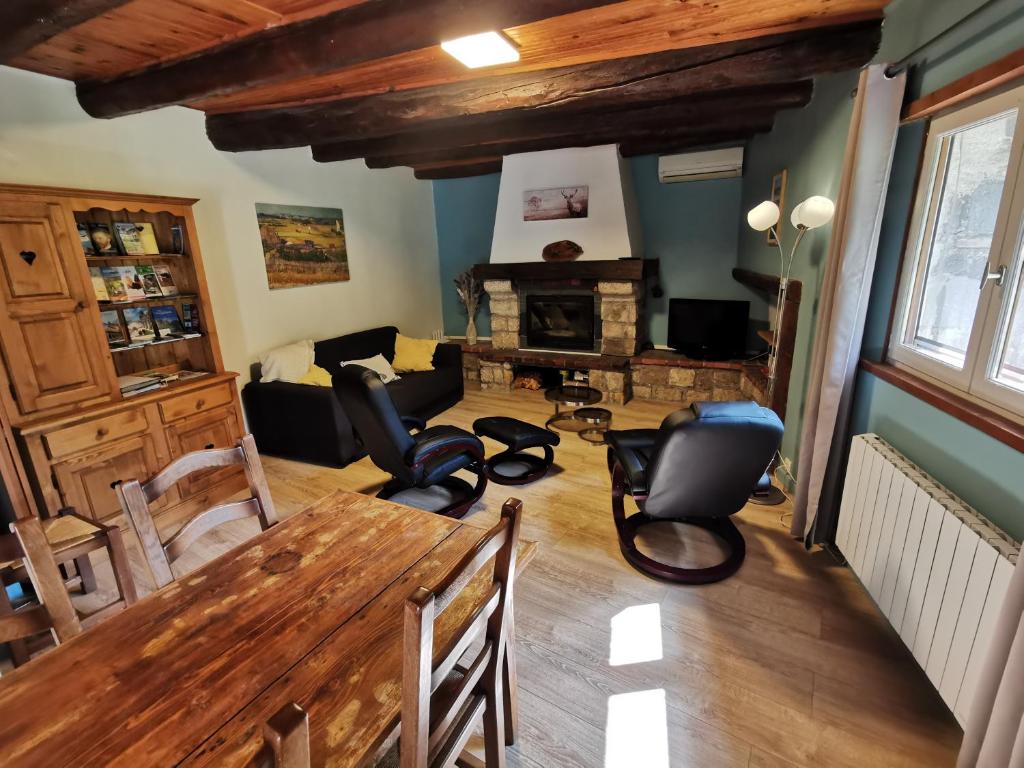 sala de estar con mesa de madera y sillas en Les gîtes Estaou Treillo, en Le Monastier sur Gazeille