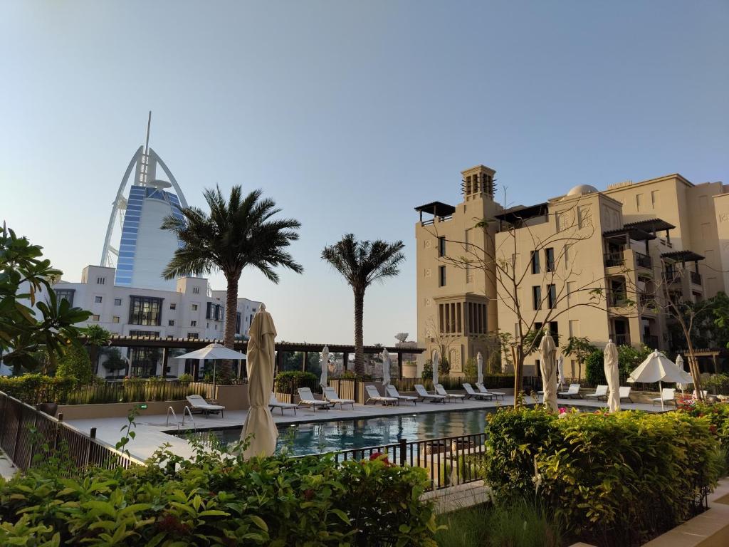a resort with a pool and buildings and umbrellas at Ultimate Stay / Next to Burj Al Arab / Upscale Luxury / Amazing Pool with a View / Perfect Holiday / Madinat Jumeirah / 2 BDR in Dubai