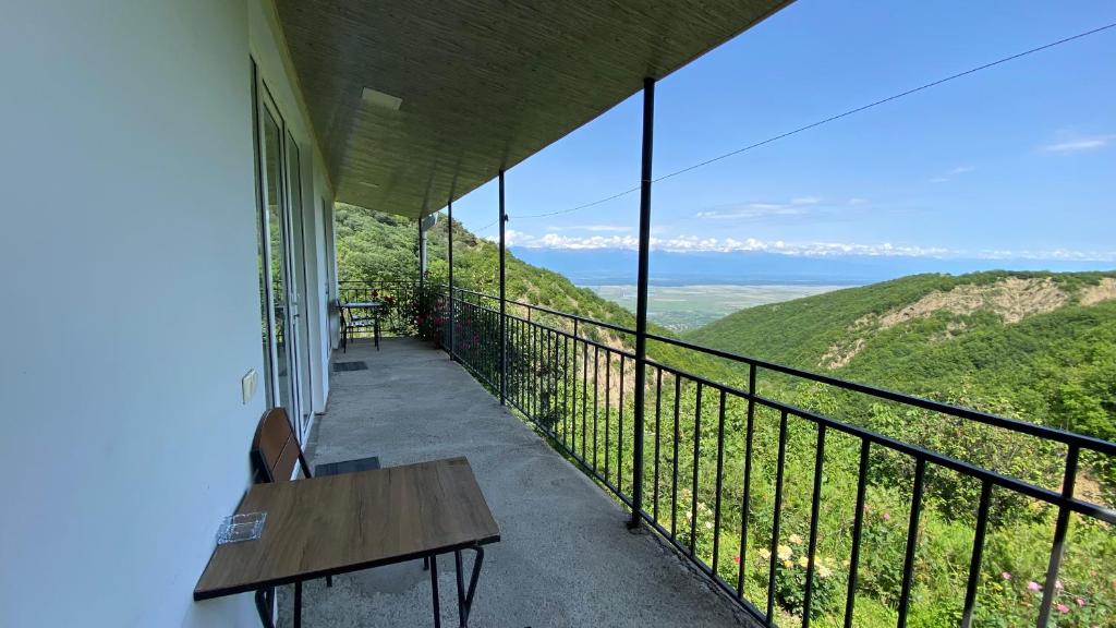 a balcony with a table and a view of the mountains at Lia's Guest House in Sighnaghi