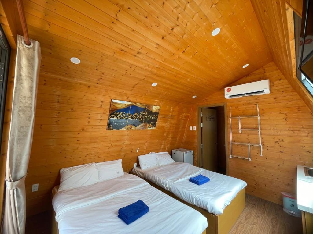 Duas camas num quarto com tecto em madeira em Tân Thành Resort em Ke Ga