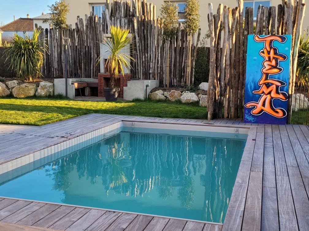 une piscine avec une terrasse en bois et une clôture dans l'établissement La Villa Thelma 5 étoiles, piscine, sauna et jacuzzi, à Granville
