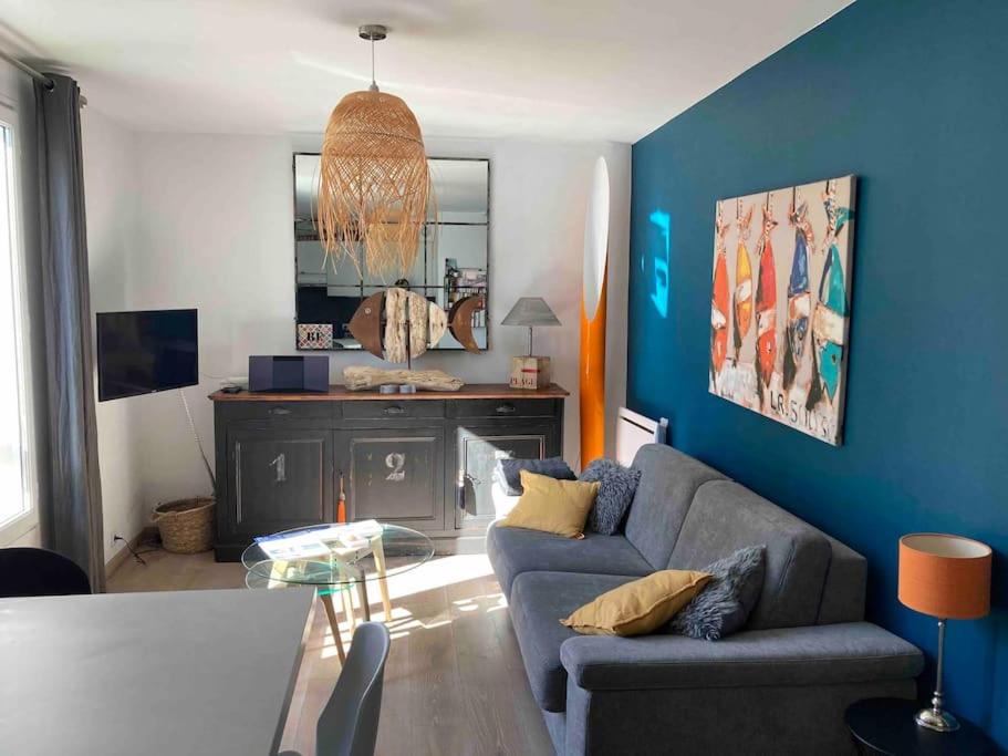 un salon avec un canapé et une table dans l'établissement EOLE, Idéalement situé sur le port de St Martin de Re, à Saint-Martin-de-Ré