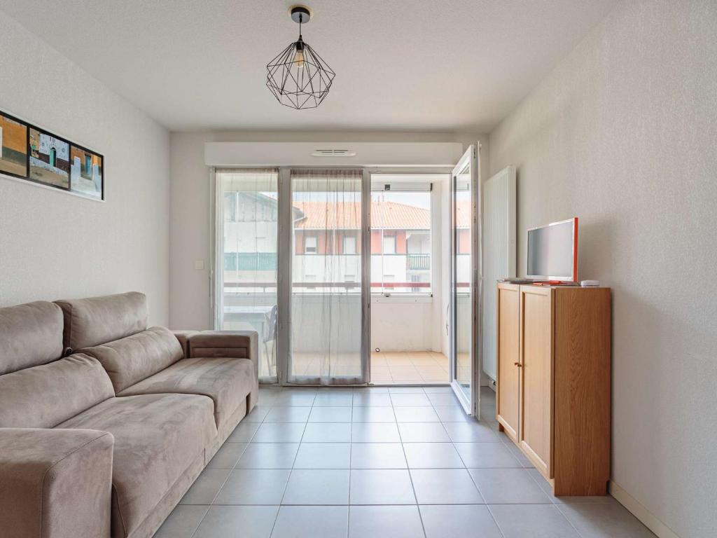ein Wohnzimmer mit einem Sofa und einem TV in der Unterkunft Appartement Hendaye, 2 pièces, 4 personnes - FR-1-2-343 in Hendaye