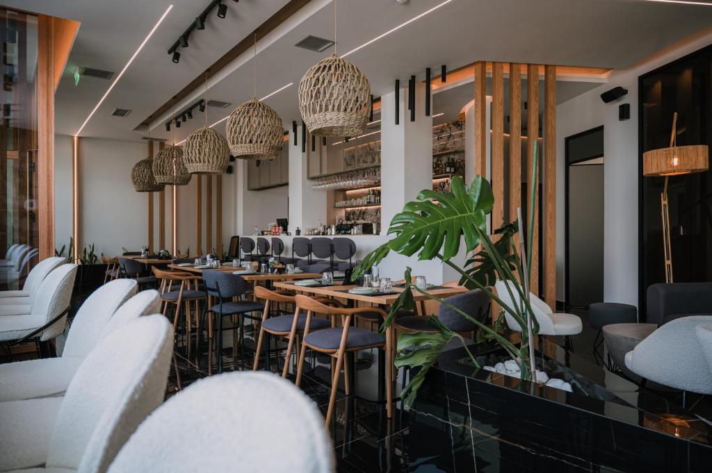 a restaurant with tables and chairs and potted plants at Agamemnon Hotel in Nafplio