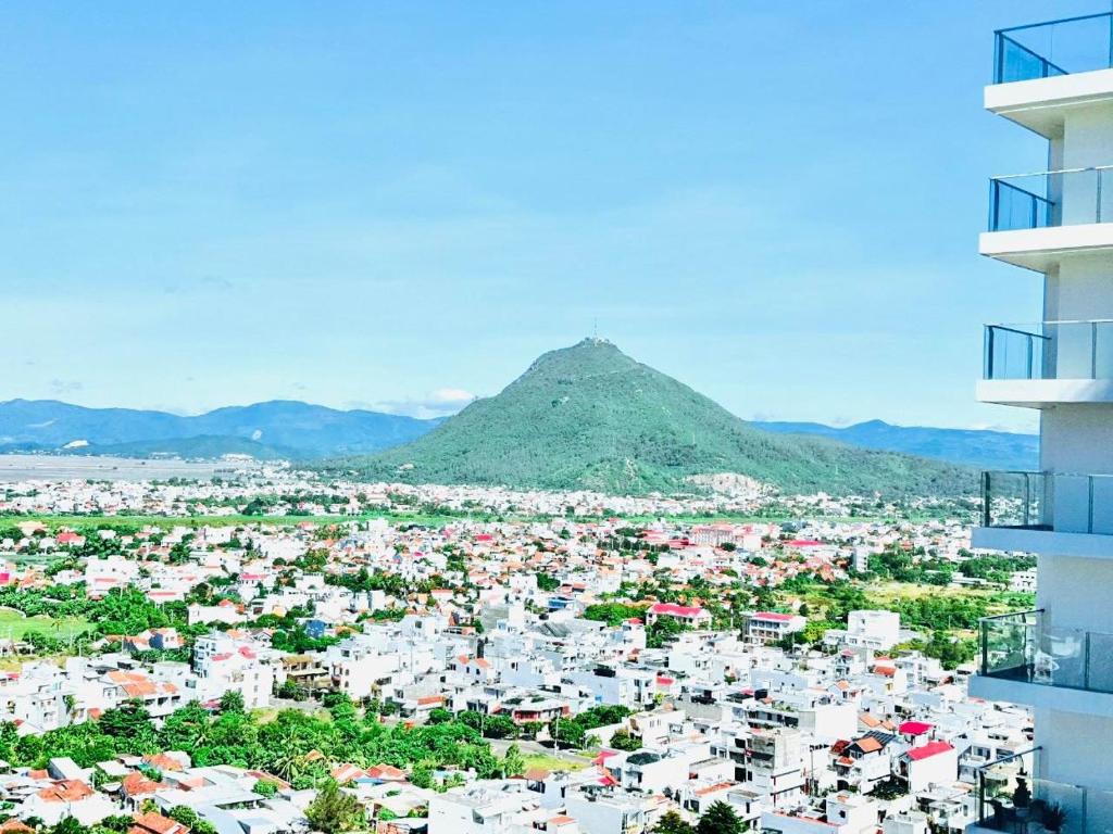 uma vista para uma cidade com uma montanha ao fundo em Hoa vàng trên cỏ xanh em Phu Yen