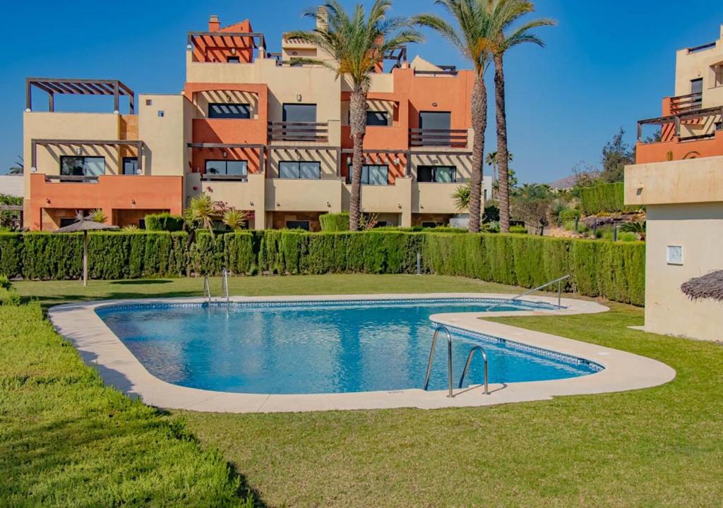 une villa avec une piscine en face d'un bâtiment dans l'établissement Apartamento en Valle del Este, à Vera