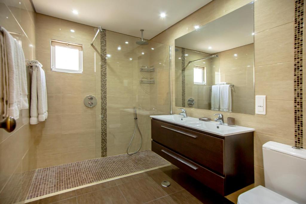 La salle de bains est pourvue d'une douche, d'un lavabo et d'un miroir. dans l'établissement Balaia Golf Village, à Albufeira