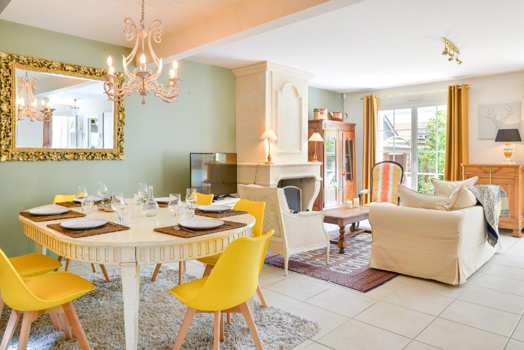 a dining room with a table and yellow chairs at Magnolia - Charmante maison avec jardin in Nantes
