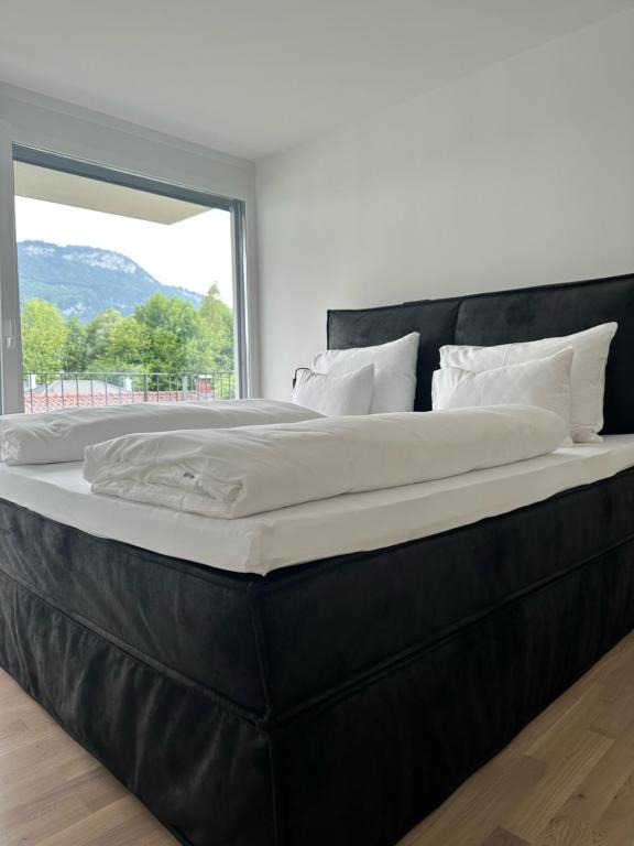 un grande letto in una stanza con una grande finestra di Village by Maier - kontaktloser Check-in a Hohenems