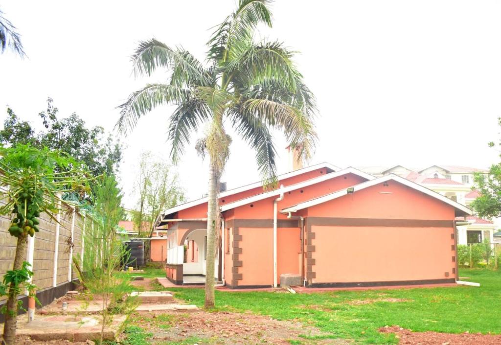 a house with a palm tree in the yard at Pacific Homes @milimani court, kakamega in Kakamega