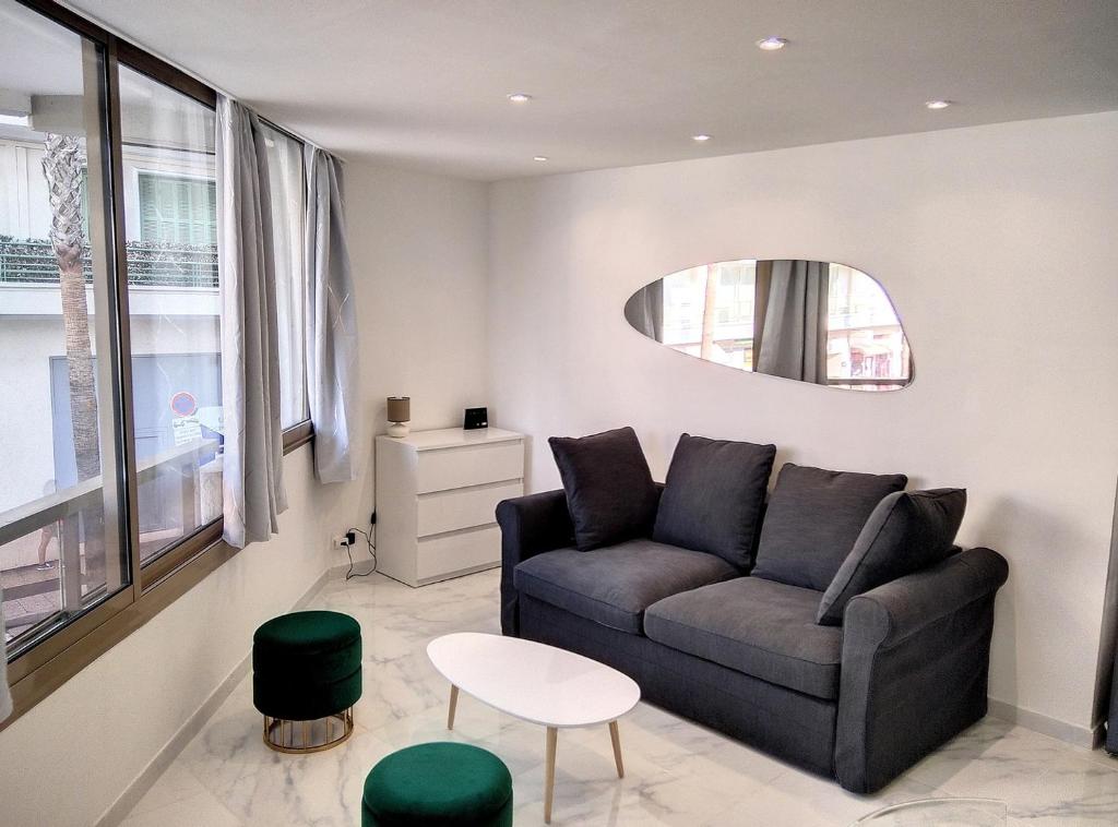een woonkamer met een bank en een tafel bij Résidence Graziella Appartement 99 in Juan-les-Pins