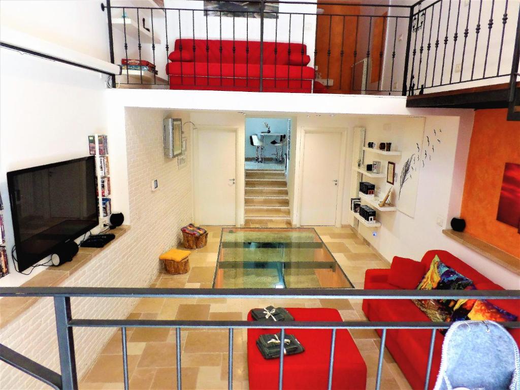 a living room with a red couch and a tv at Regina Viarum Apartment, Historic City Centre in Brindisi