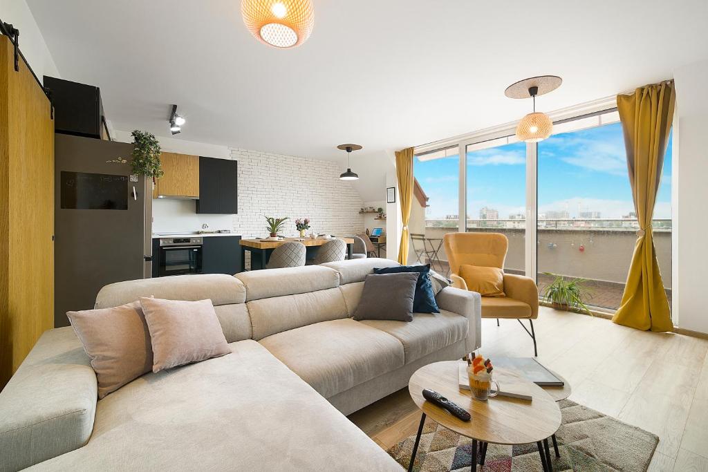 uma sala de estar com um sofá, uma mesa e uma cozinha em Top Central Maisonette with Underground parking em Sófia
