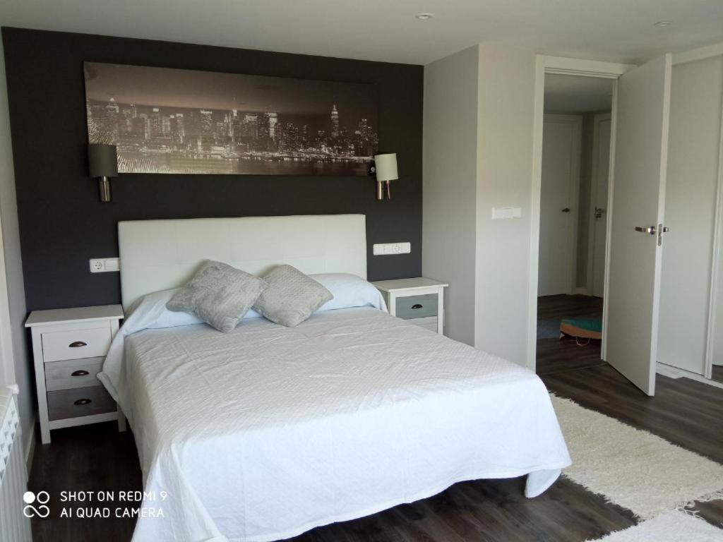 ein Schlafzimmer mit einem weißen Bett und einer schwarzen Wand in der Unterkunft Casa Sartages in Ribadumia