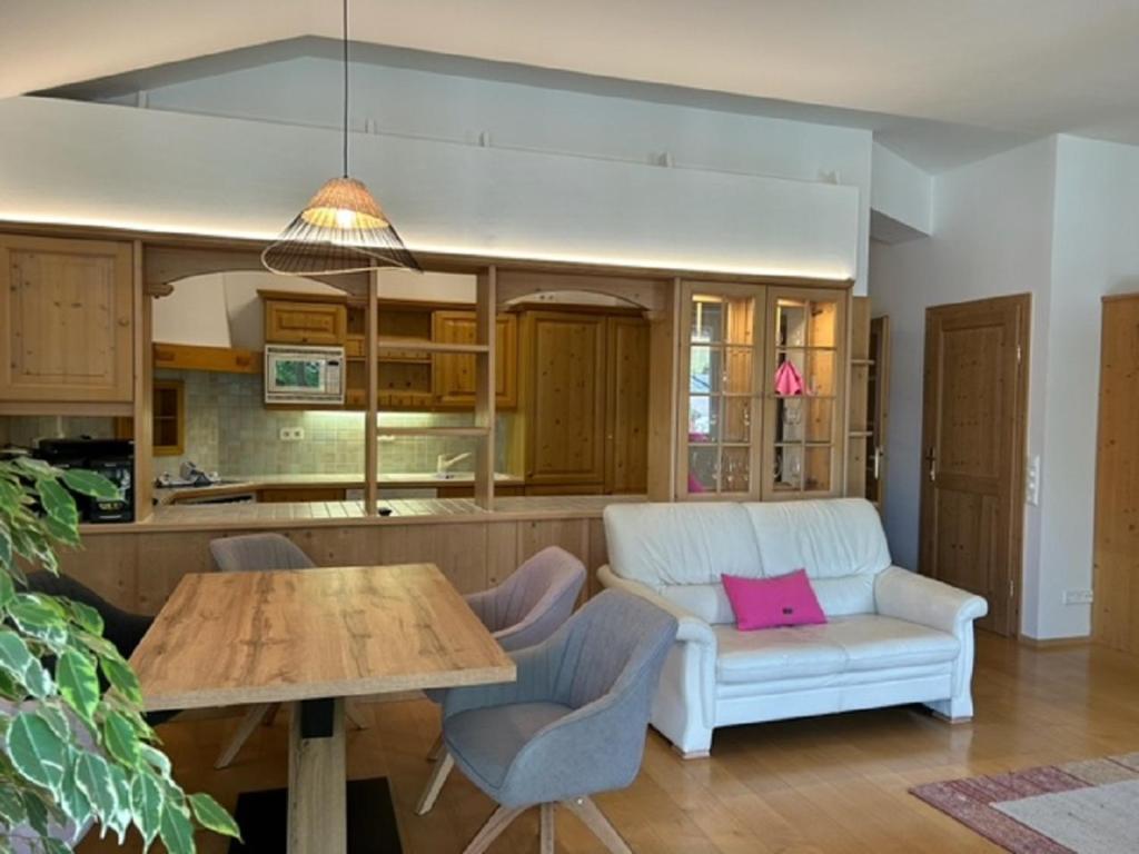 uma sala de estar com um sofá branco e uma mesa em Haus Silent Apartment TOBI TOP 27 em Schladming