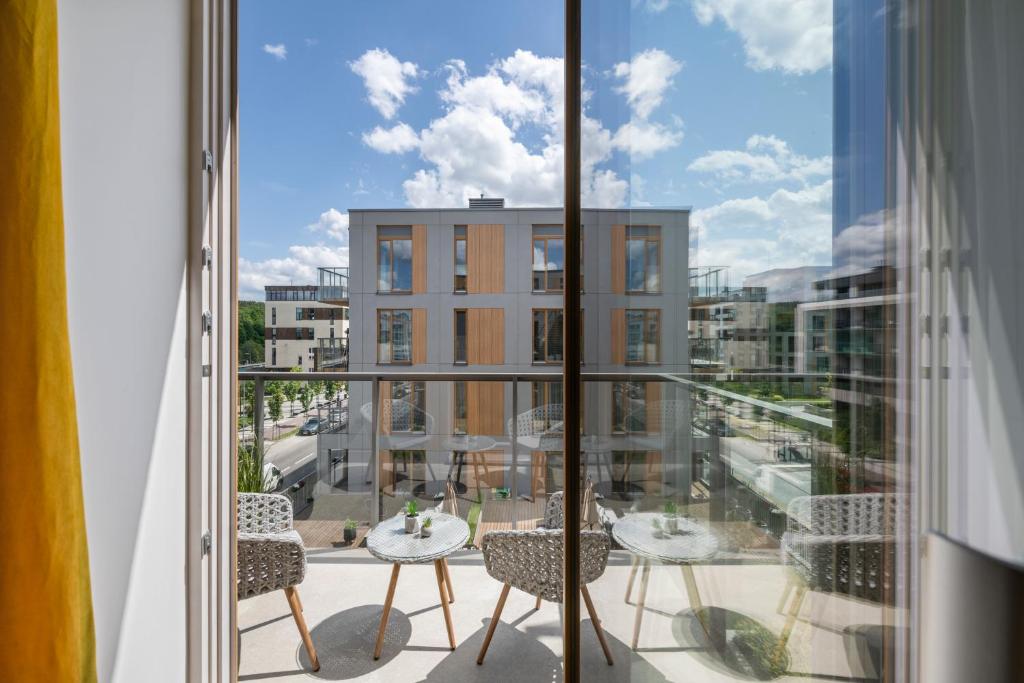 a balcony with tables and chairs and a view of a city at Žalia kopa Vilnius Paupys in Vilnius