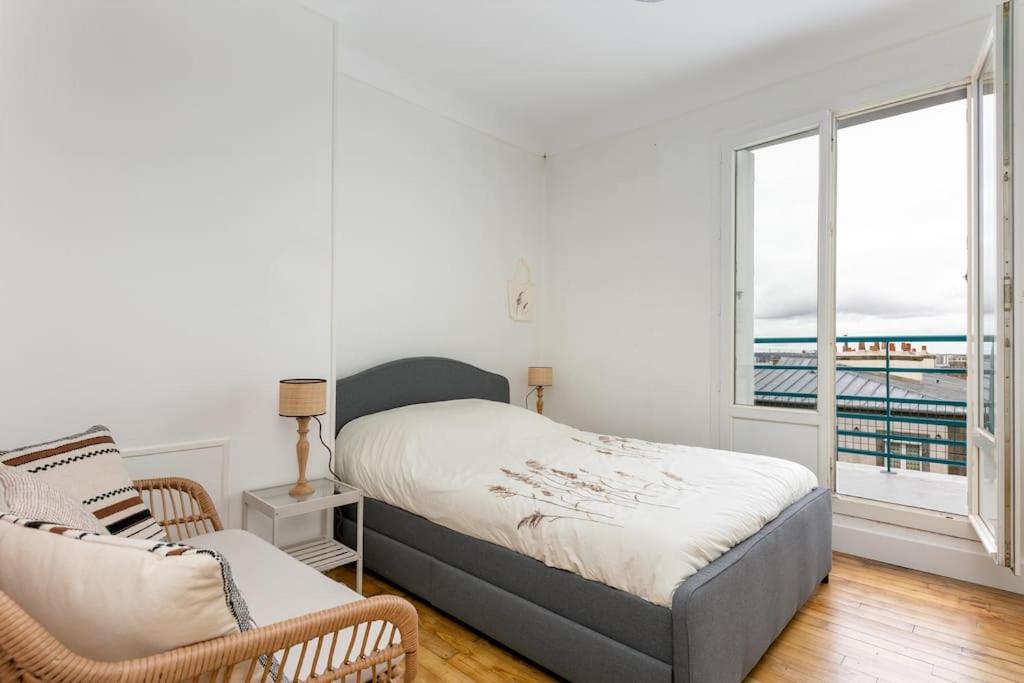 a bedroom with a bed and a chair and a window at Vue mer &#47; Jaurès-Centre-Ville &#47; Appart Lumineux in Brest