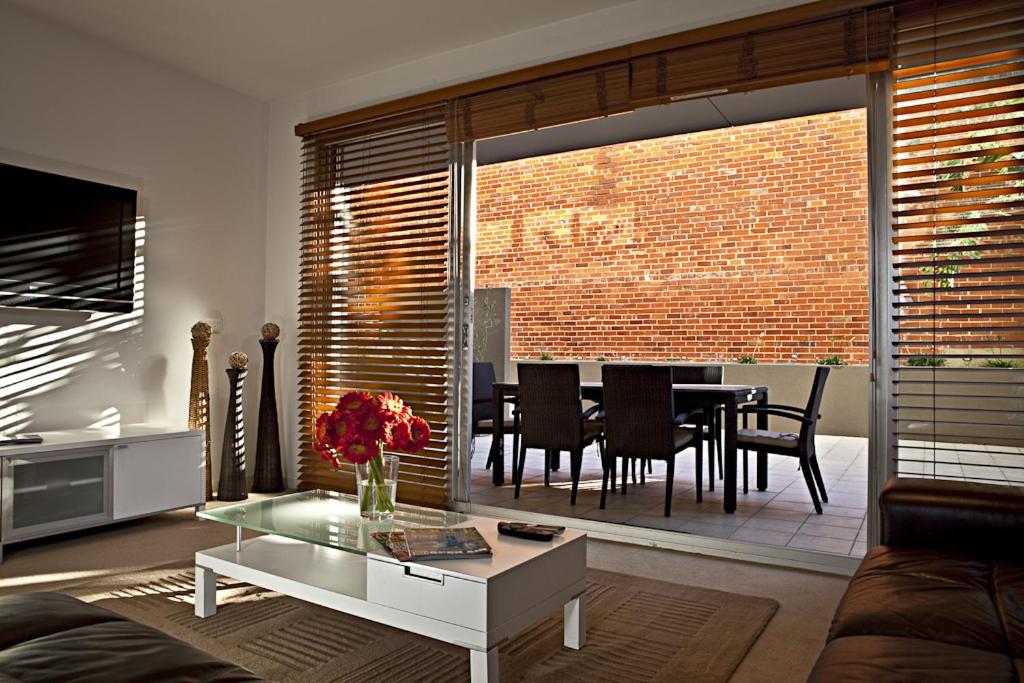 a living room with a table and a dining room at Brighton Bay Apartments in Melbourne