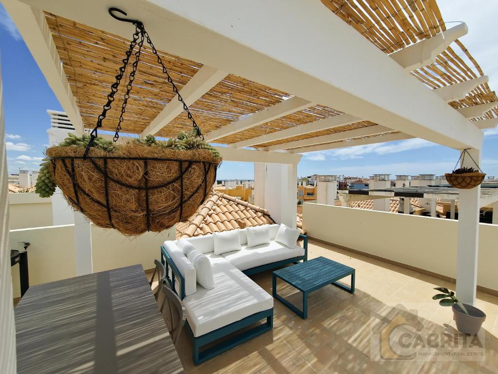 una sala de estar con una cesta colgante en el techo en Royal Terrace T2 by YHA en Conceição