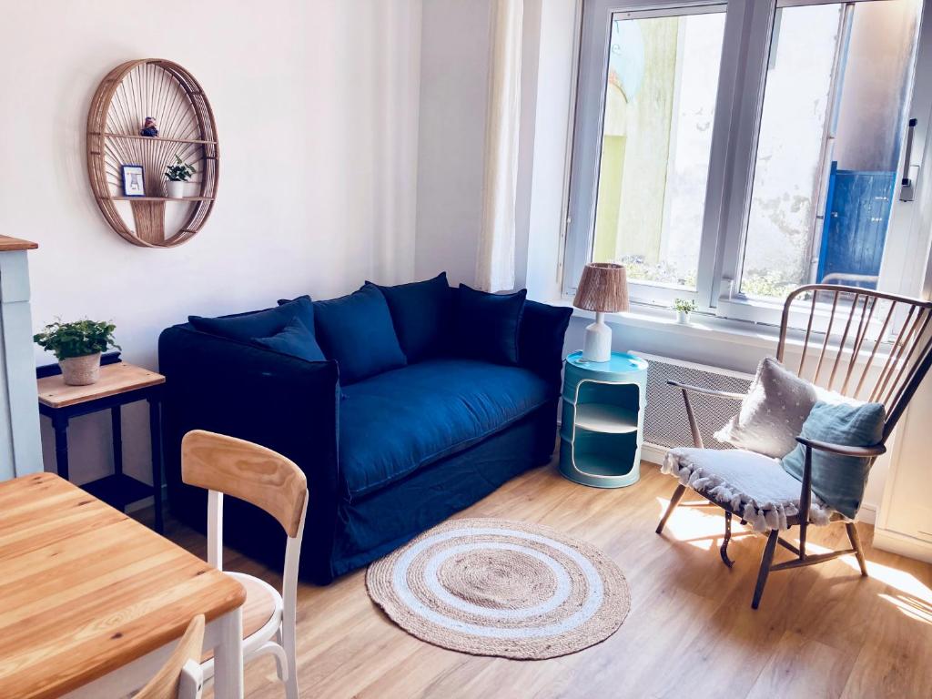 a living room with a blue couch and chairs at Studio Tehani in Quiberon