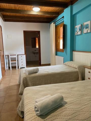Duas camas num quarto com paredes azuis em LA SOCIEDAD em Arens de Lledó