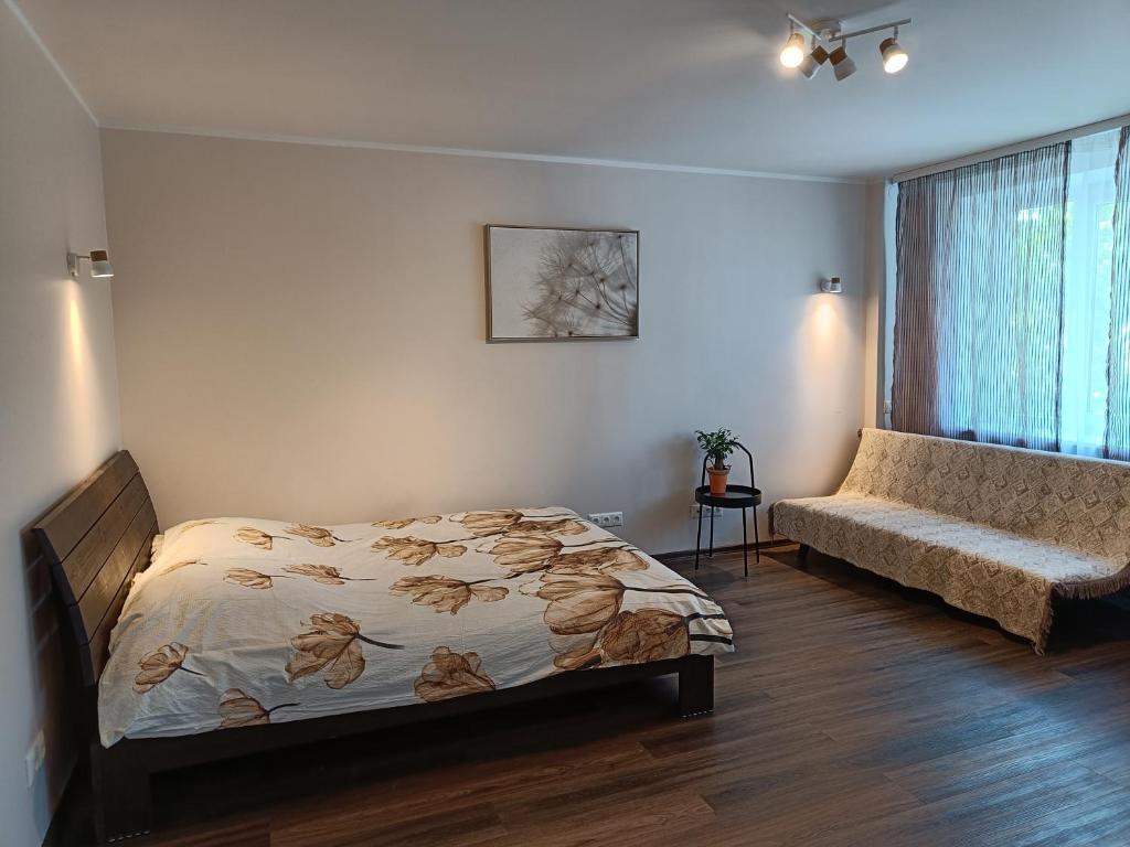 a bedroom with a bed and a window and a couch at NarvaCenter 2 in Narva