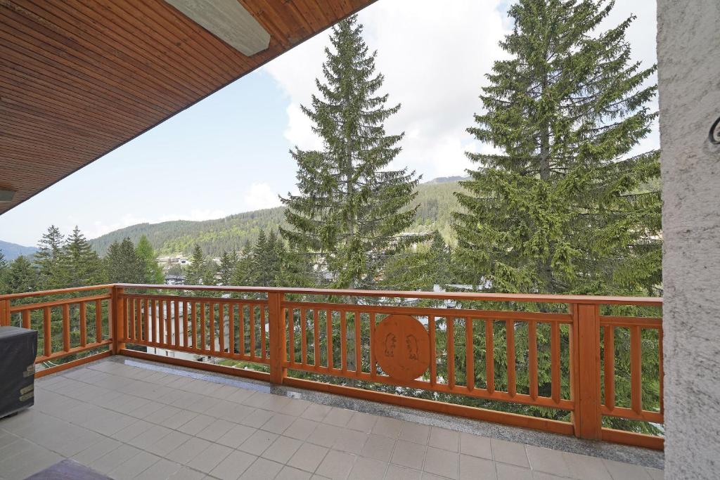 a wooden balcony with a view of trees and mountains at iFlat Apartment Madonna di Campiglio Casa di Betti in Madonna di Campiglio