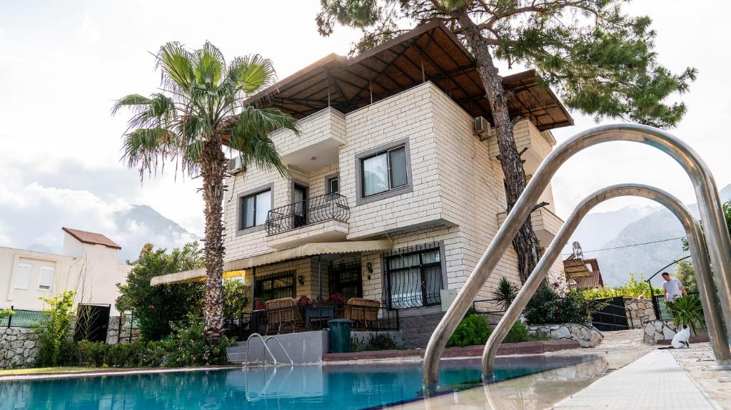a house with a swimming pool in front of a house at Spacious Villa with Sea and Mountain View in Kemer
