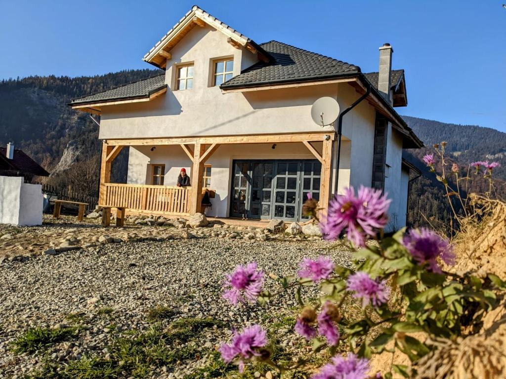 una casa con fiori viola di fronte di The Origin ● Mountain Guesthouse ● Magura a Măgura