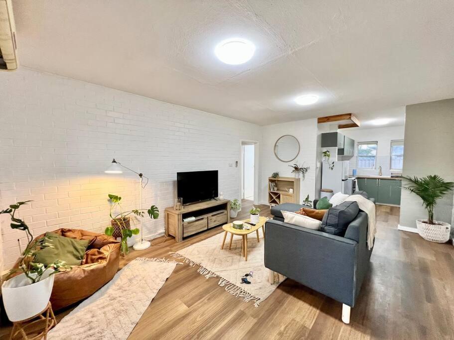 ein Wohnzimmer mit einem Sofa und einem TV in der Unterkunft Immaculate Stylish Apartment in South Hedland