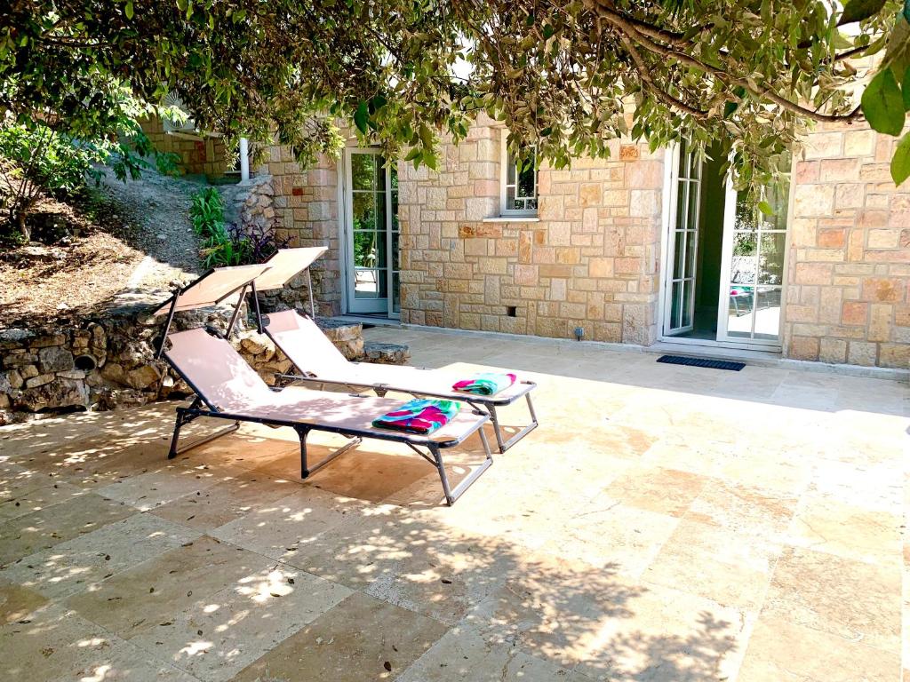 a chair sitting on a patio under a tree at Maison de ville dans la Villa Brise des Pins in Le Cannet